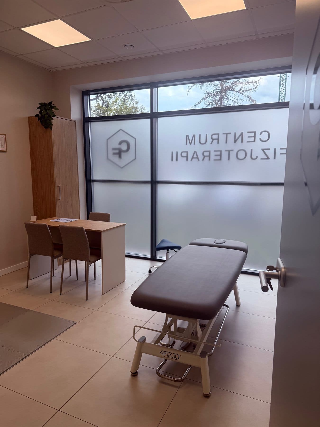 Gabinet z leżanką rehabilitacyjną przy przeszklonej ścianie