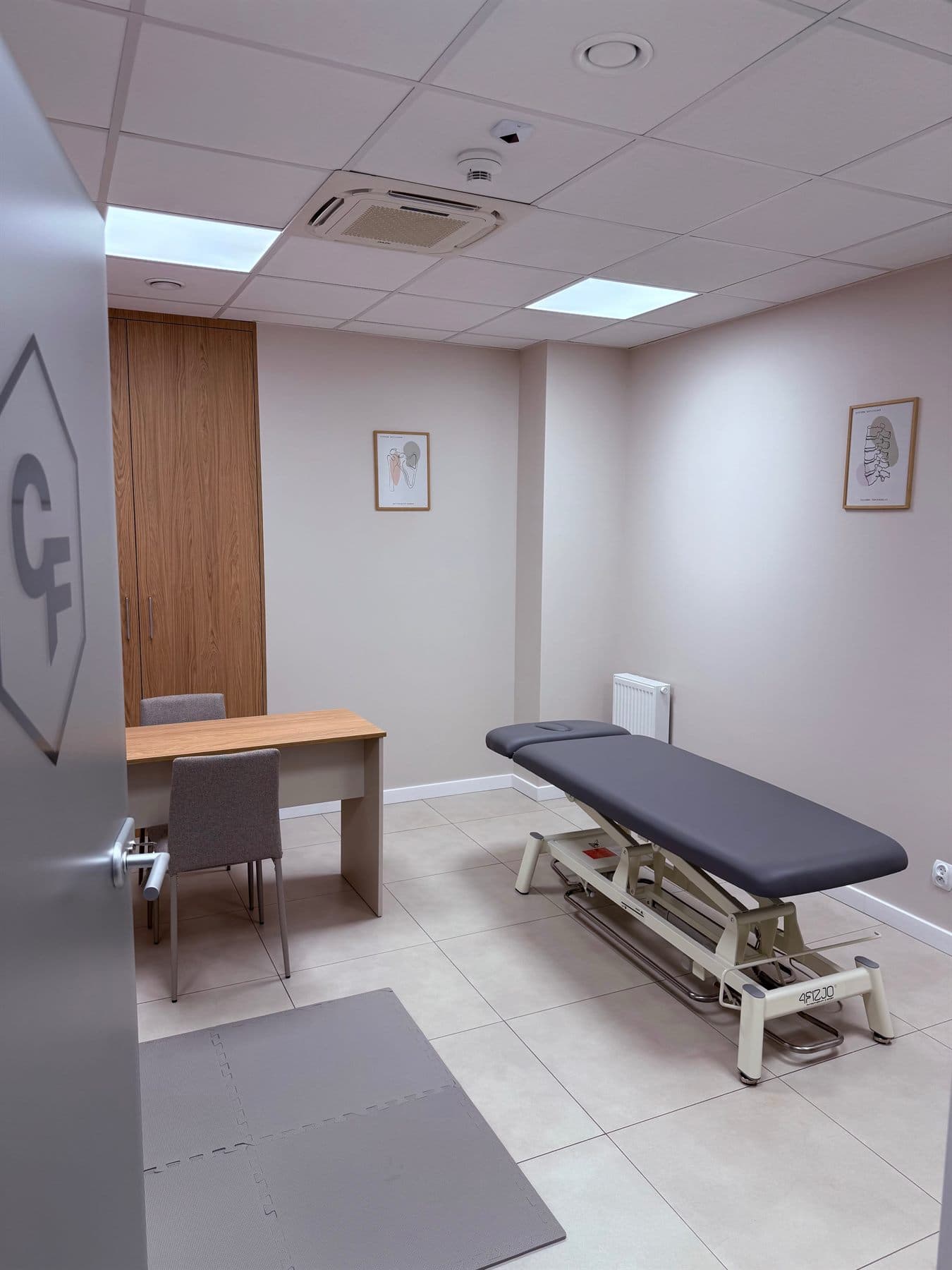 Gabinet terapii ze stołem rehabilitacyjnym i biurkiem
